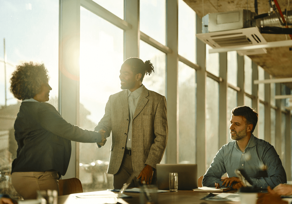 People shaking hands in a meeting room.
