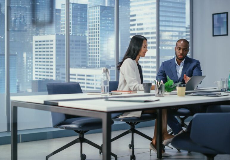 Two colleagues discussing in modern office.
